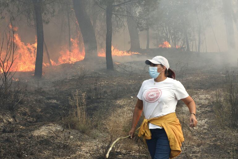 En algunas zonas, por falta de bomberos que estan en otros parajes en llamas, los vecinos de estos pueblos se han tenido que organizar para que las llamas no lleguen a los cascos urbanos. Es el caso de Elisabete Pinto (c), que ha acudido para ayudar. Un equipo de 248 efectivos de la Unidad Militar de Emergencias (UME) de España llegó este miércoles a Portugal para sumarse a las labores de combate contra la ola de incendios forestales.