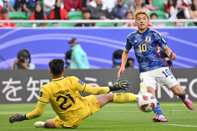 Japan's midfielder #10 Ritsu Doan looks on as Indonesia's goalkeeper #21 Ernando Ari slides past the ball during the Qatar 2023 AFC Asian Cup Group D football match between Japan and Indonesia at al-Thumama Stadium in Doha on January 24, 2024. (Photo by HECTOR RETAMAL / AFP)