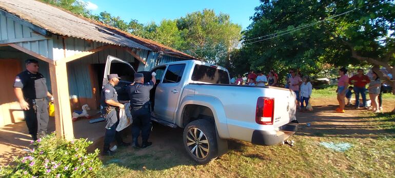 Efectivos de la Policía Nacional revisan el interior de la camioneta baleada en Villa Ygatimí. (gentileza).