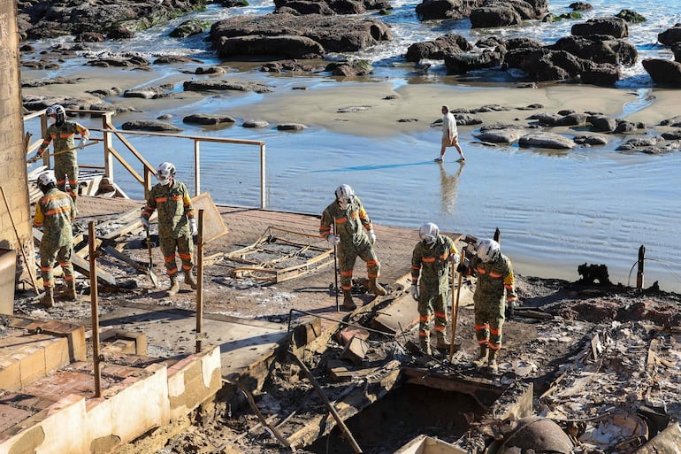 Rescatistas verifican los restos de una casa que estaba en la costa de Malibú y que fue consumida por las llamas.