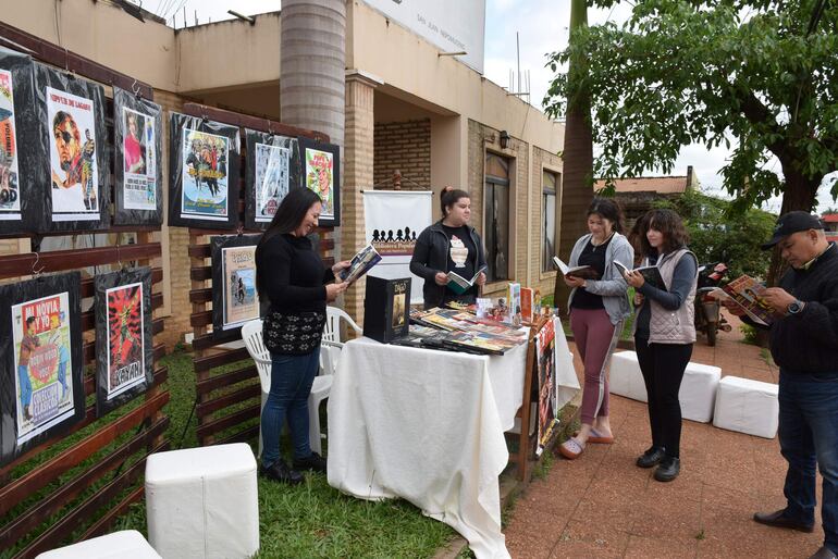 Jóvenes nepomucenos leyendo los libros de historietas de Robin Wood durante la apertura de la muestra de las obras del caazapeño.