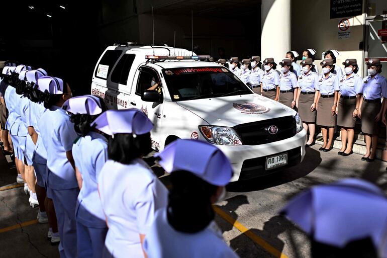 Oficiales de policía y enfermeras observan la ambulancia que transportaba los restos de las víctimas de un incendio mortal en un autobús escolar el 2 de octubre.