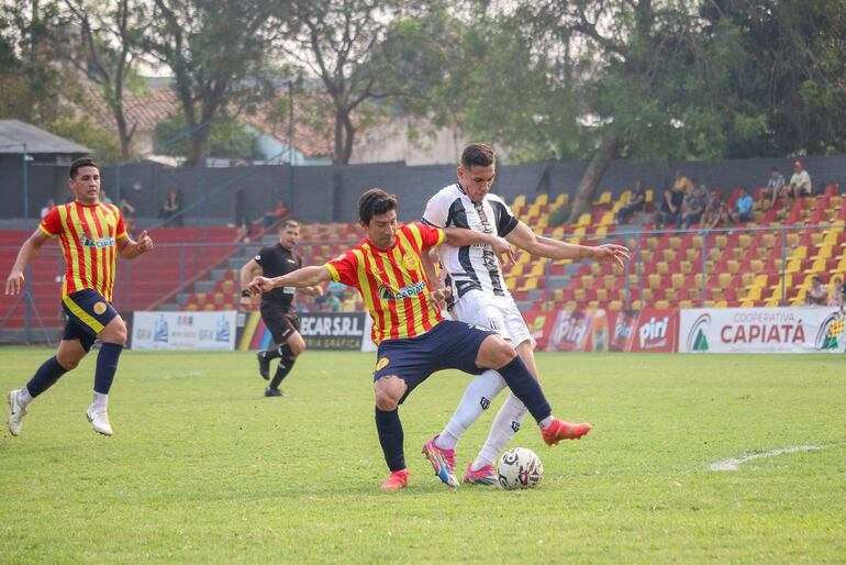 El volante aurirrojo Héctor Villamayor intenta cubrir el esférico ante la marca de Roland Escobar.  (Foto: APF)