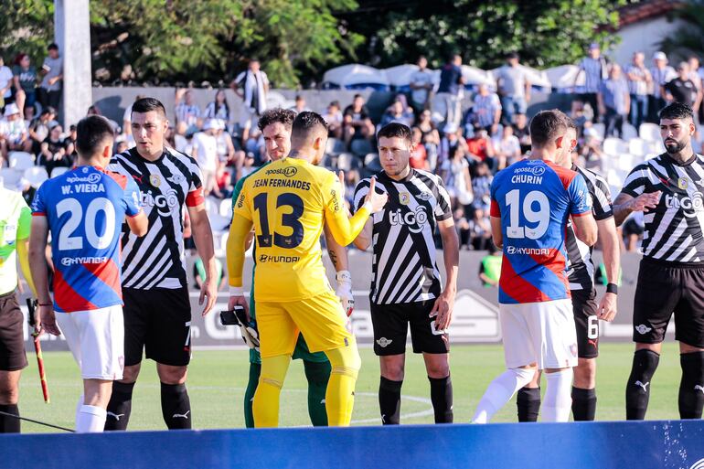 Los futbolistas de Cerro Porteño y Libertad se saludan previo al partido por el fútbol paraguayo en el estadio La Huerta, en Asunción.