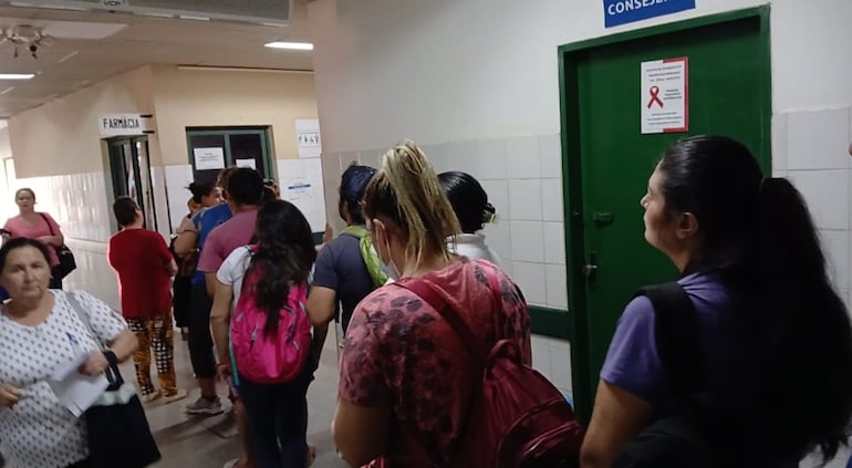 Larga fila en la farmacia para retirar medicamentos.