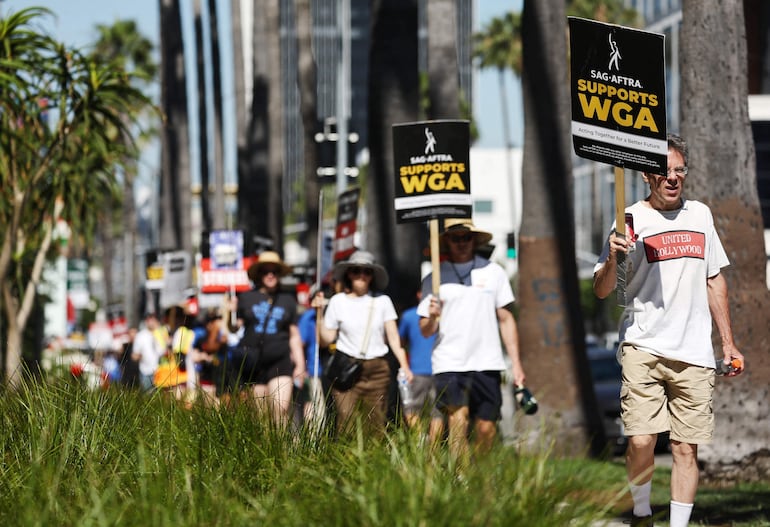 Un letrero dice 'SAG-AFTRA apoya a WGA' mientras los miembros de SAG-AFTRA caminan en la línea de piquete en solidaridad con los trabajadores en huelga de WGA (Writers Guild of America) frente a las oficinas de Netflix el 13 de julio de 2023 en Los Ángeles , California.