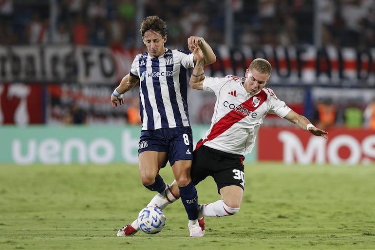 El paraguayo Matías Galarza fue gran figura de Talleres este miércoles aquí disputa el balón con Franco Mastantuono.