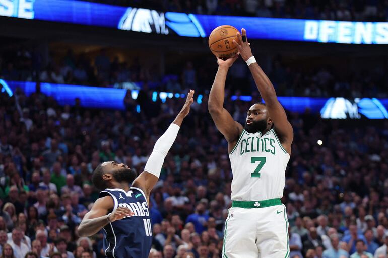 Jaylen Brown (d), jugador de Boston Celtics, lanza el balón frente a Tim Hardaway Jr., jugador de Dallas Mavericks, en el tercer partido de las finales de la NBA 2023-2024 en el estadio American Airlines Center, en Dallas, Texas.