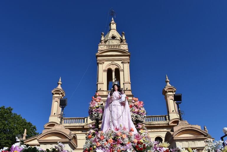 La sagrada imagen de la Virgen del Rosario. De fondo  sobresale la cúpula del templo parroquial.