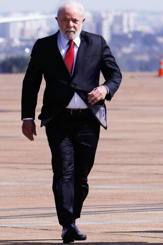 Brazilian President Luiz Inacio Lula da Silva gestures as he arrives to the Brasilia Air Force Base to attend a ceremony commemorating the 150th birthday of Brazilian aviator and inventor Alberto Santos Dumont, considered the patron saint of the Brazilian Air Force, in Brasilia on July 20, 2023. (Photo by Sergio Lima / AFP)