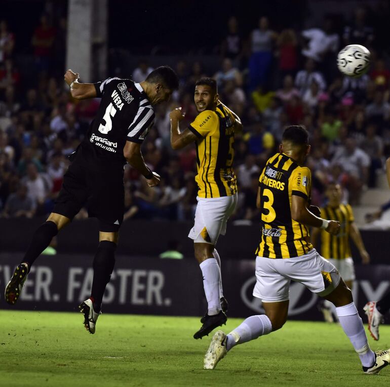 Diego Viera ya conecto de cabeza el balón, que lleva destino de red, ante la mirada de los jugadores aurinegros.