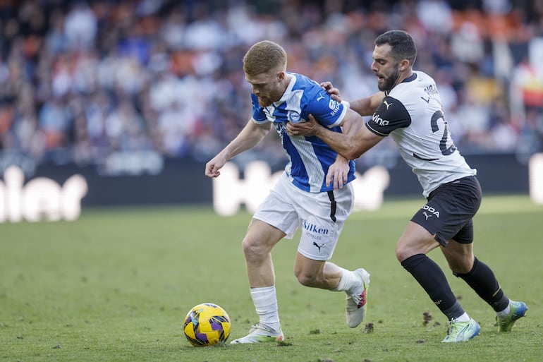 El centrocampista del Valencia Luis Rioja (d) pelea un balón con el centrocampista del Alavés Carlos Vicente celebra durante el partido de LaLiga ante el Alavés este domingo en el estadio de Mestalla en Valencia.