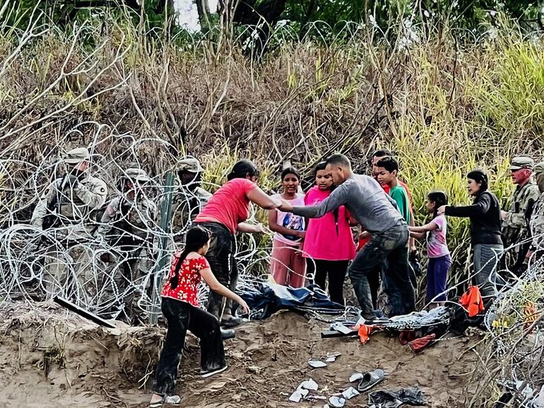 Un grupo de migrantes cruzan el río Bravo para ingresar a la frontera con Estados Unidos hoy, desde la ciudad de Matamoros (México).