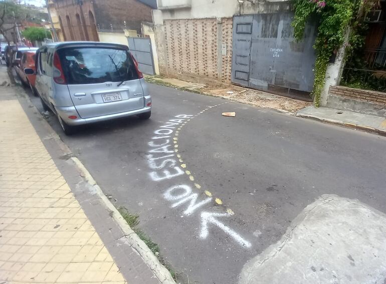 Vista de la calzada pintarrajeada para "reservar" el estacionamiento.