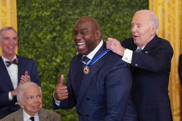 El exbasquetbolista Earvin "Magic" Johnson recibe la condecoración de parte del presidente Joe Biden.