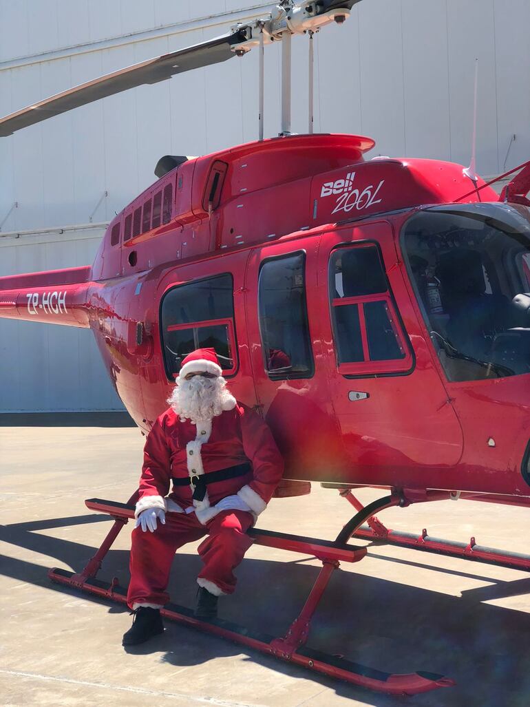 Santa posa junto al helicóptero.