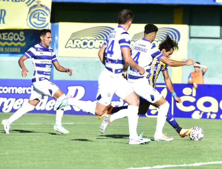 Jorge Benítez, futbolista de Sportivo Luqueño, remata el balón ante la marca de los jugadores del 2 de Mayo en un partido por la primera fecha del torneo Apertura 2024 del fútbol paraguayo en el estadio Feliciano Cáceres, en Luque.