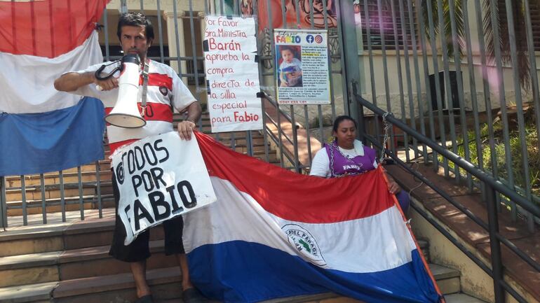 Se encadenan por Fabio para exigir a la ministra Teresa Barán que cumpla su promesa de adquirir una silla especial.