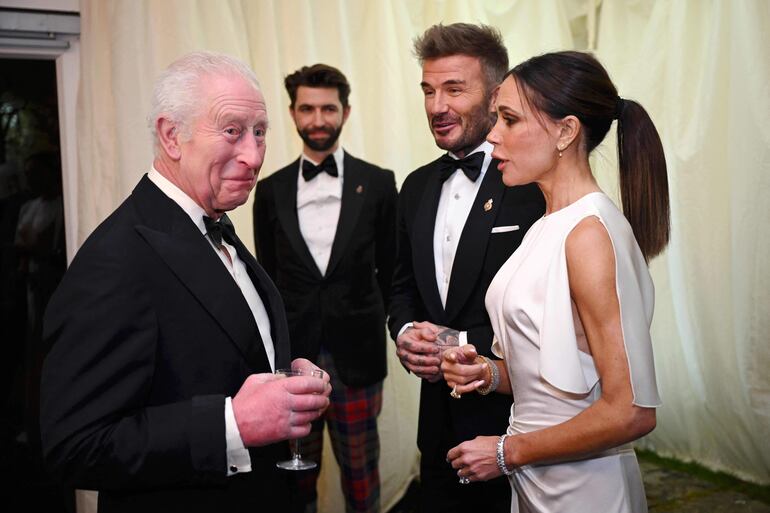 El rey Carlos III de Gran Bretaña junto a la diseñadora de moda británica Victoria Beckham y el exfutbolista británico David Beckham.