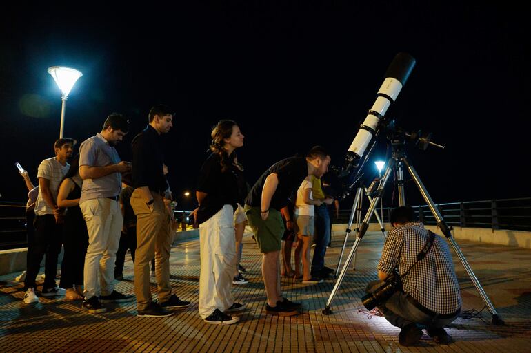 Un hombre observa por un telescopio el eclipse lunar parcial este martes, en Asunción (Paraguay).