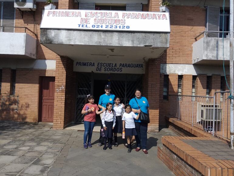 Docentes y estudiantes comparten en la entrada de la Primera Escuela Paraguaya de Sordos