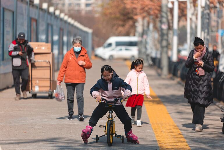 La gente camina frente al mercado de mariscos de Huanan, cerrado y vallado, en Wuhan, provincia de Hubei, China.