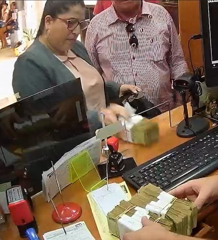 La abogada Elizabeth Noemí Anzoategui Rivarola cuando retiraba los fajos de dinero del banco. (captura de video).