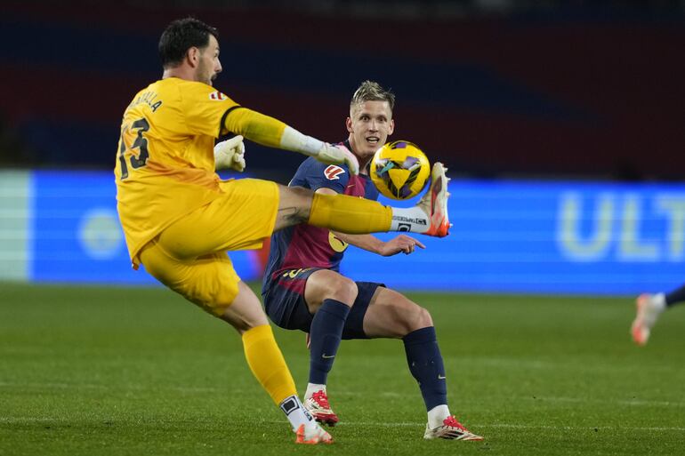 BARCELONA, 17/02/2025.- El guardameta argentino del Rayo Vallecano, Augusto Batalla (i), golpea el balón ante el centrocampista del FC Barcelona, Dani Olmo, durante el partido de LaLiga de fútbol que FC Barcelona y Rayo Vallecano disputan este lunes en el estadio Lluis Companys. EFE/Alejandro García.
