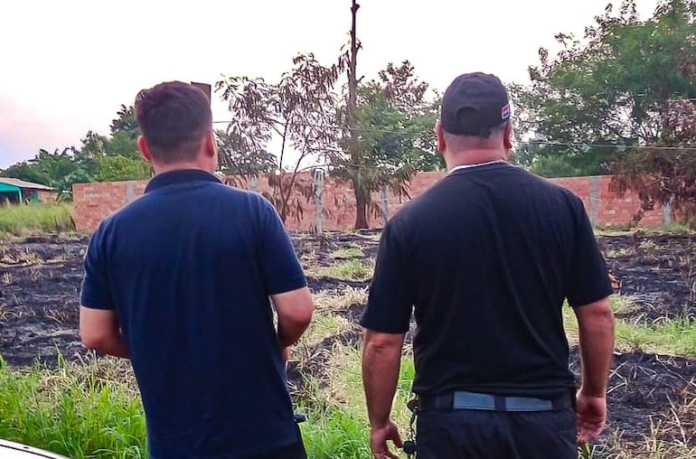 Los fiscales en un terreno baldío donde la quema de basura se extendió hacia el pastizal.