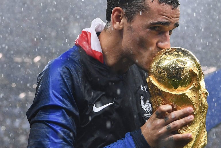 (FILES) France's forward Antoine Griezmann kisses the World Cup trophy during the trophy ceremony at the end of the Russia 2018 World Cup final football match between France and Croatia at the Luzhniki Stadium in Moscow on July 15, 2018. France's 2018 World Cup-winning star Antoine Griezmann on September 30, 2024 announced his retirement from international football, bringing to an end a 10-year career with his country. (Photo by FRANCK FIFE / AFP) / RESTRICTED TO EDITORIAL USE - NO MOBILE PUSH ALERTS/DOWNLOADS