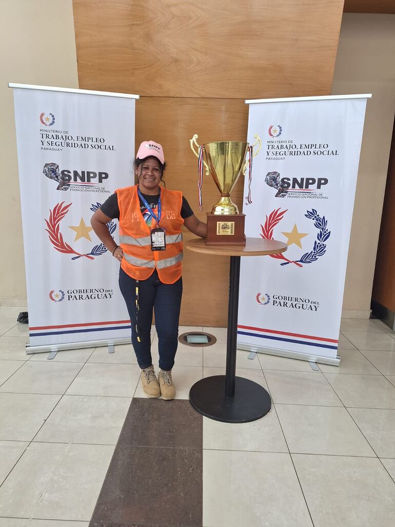 Angélica Verón con el trofeo del concurso de maquinaria pesada.