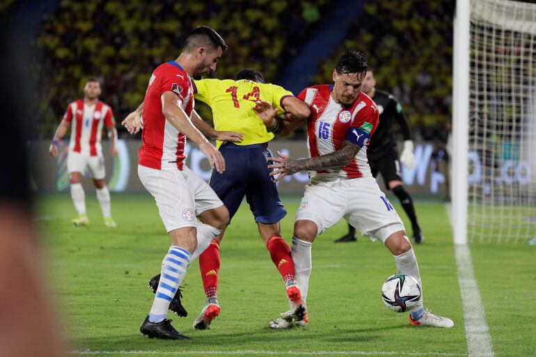 Luis Díaz (c), jugador de la selección de Colombia, disputa el balón con Gustavo Gómez (d) y Mathías Villasanti, futbolistas de la selección paraguaya, en un partido Eliminatorias Sudamericanas al Mundial 2022 en el estadio Metropolitano, en Barranquilla, Colombia.