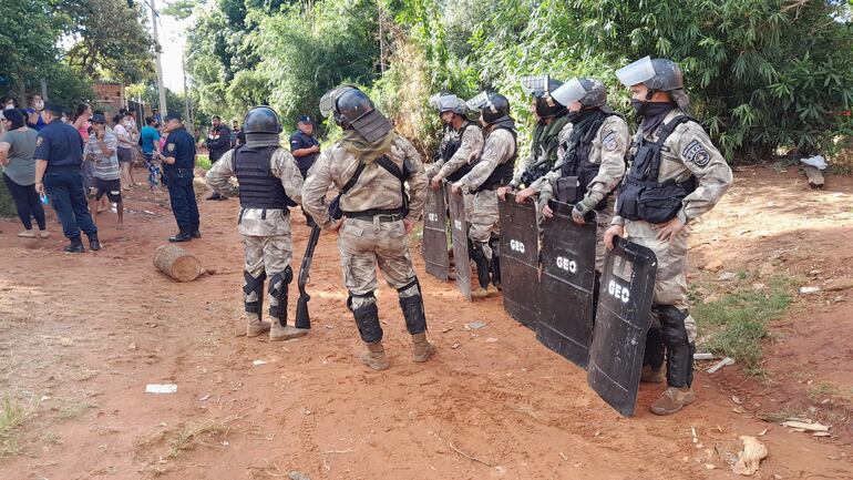 Antimotines de la policía resguardan la propiedad en donde fueron enterrados el producto químico para su neutralización.