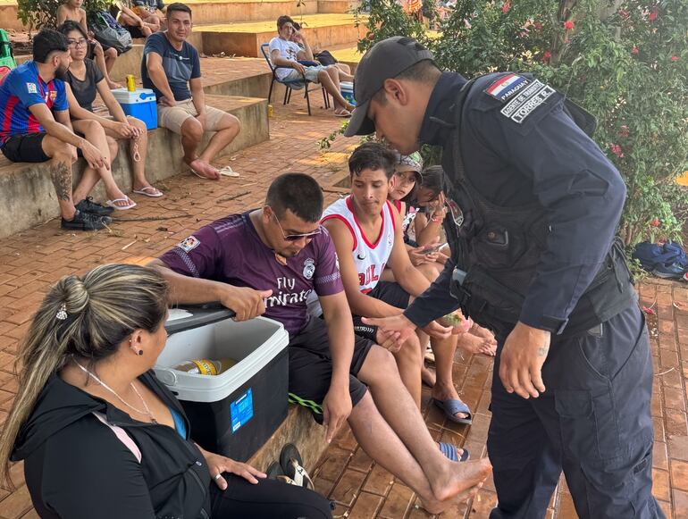 Un empleado municipal inspecciona la conservadora de un visitante para asegurarse de que no contenga envases de vidrio.