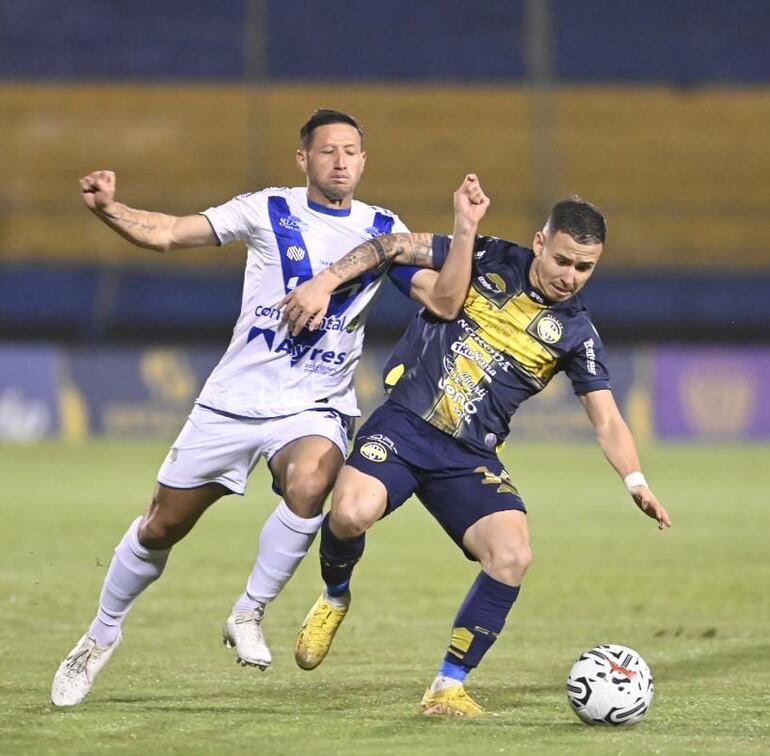 González y Mendoza pelean por la posesión del balón