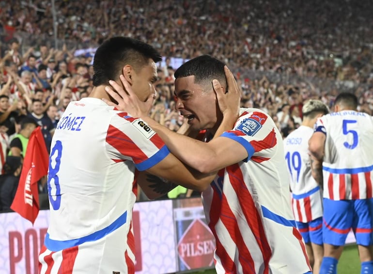 Diego Gómez y Miguel Almirón (d), jugadores de la selección de Paraguay, celebran el gol en el partido frente a Brasil por las Eliminatorias Sudamericanas 2026 en el estadio Defensores del Chaco, en Asunción.