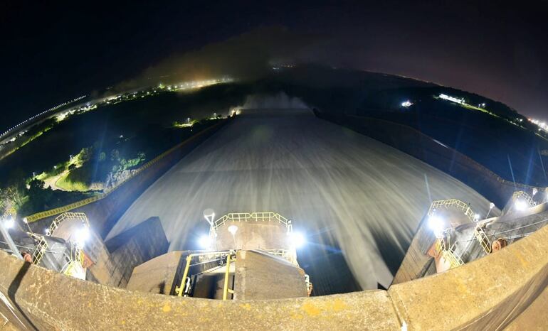 Vista nocturna de la represa de Itaipú con las compuertas abiertas.