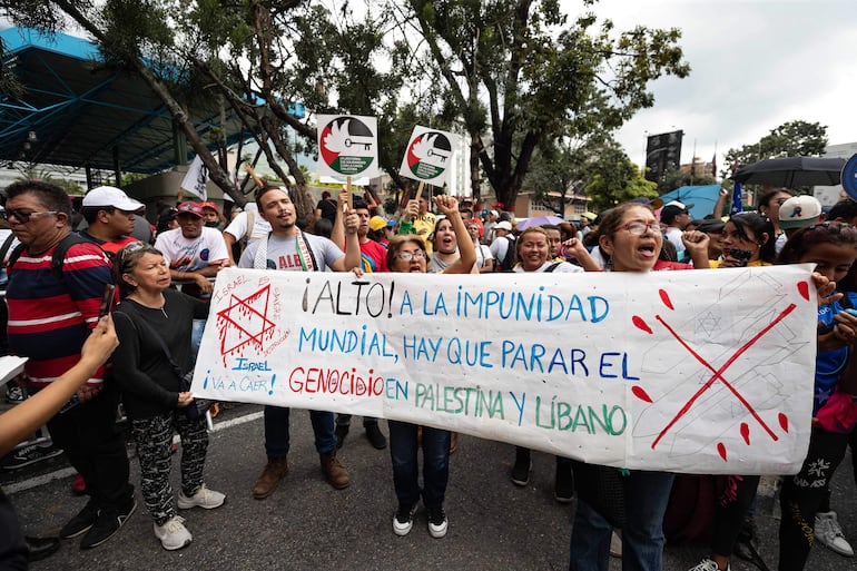 Personas participan en una manifestación pro Palestina este sábado, en Caracas (Venezuela). Cientos de personas se movilizaron este sábado en Caracas para entregar un documento en la sede de la ONU en Venezuela en el que exigen al organismo multilateral "asumir su responsabilidad" y "poner fin a la impunidad de la ocupación israelí" en Palestina.