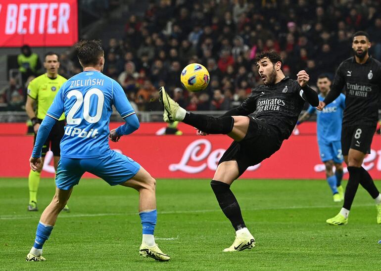 El francés Theo Hernández, capitán del AC Milan, intenta dominar el balón ante la presencia del polaco Piotr Zieliński, centrocampista del Napoli, durante el partido disputado ayer