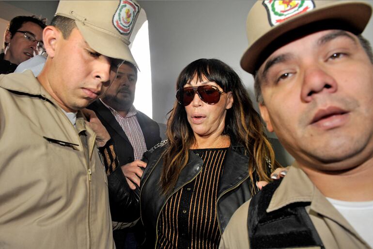 Moria Casán, custodiada por dos policías, el primer día que estuvo presa en Paraguay.