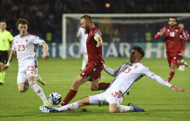 Varazdat Haroyan (C) de Armenia en acción contra Nathan Broadhead (L) y Kieffer Moore (R) de Gales durante el partido de clasificación del Grupo D de la UEFA EURO 2024 entre Armenia y Gales en Ereván, Armenia, el 18 de noviembre de 2023.