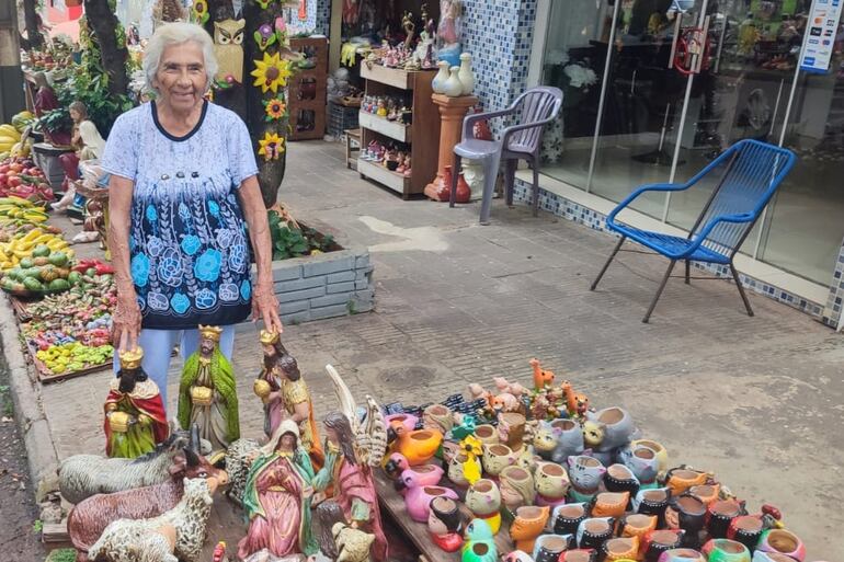 Doña Isabel Fernández, artesana de Areguá, lleva 27 años de visita ininterrumpida a Encarnación con su atractiva y colorida oferta de artesanía navideña en cerámica.