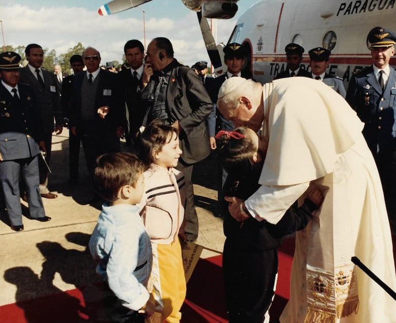 El papa Juan Pablo II abraza a unos niños a su llegada en el espigón presidencial, en su visita al Paraguay.