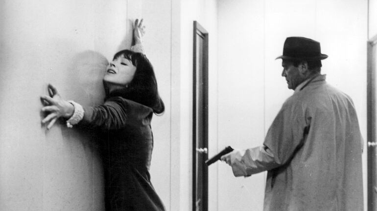 Eddie Constantine apunta con una pistola a Anna Karina en “Alphaville” (Jean-Luc Godard, 1965).