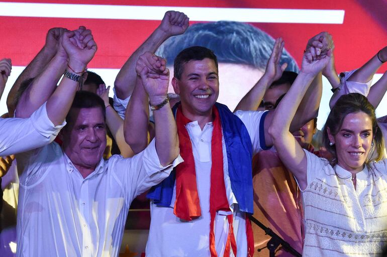 Santiago Peña (C), su esposa Leticia Ocampos y Horacio Cartes, luego de la victoria del primero en las elecciones del 30 de abril de 2023.