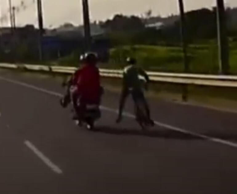 Momento en el que acompañante en moto patea al ciclista.