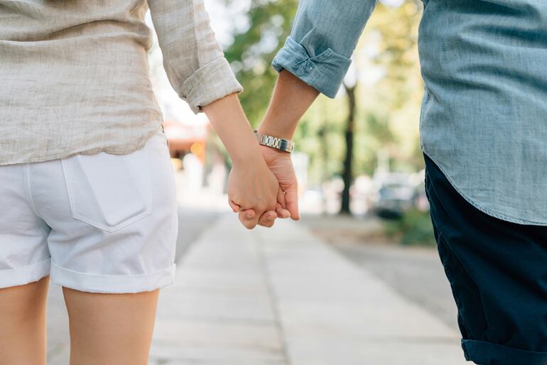 Caminando juntos por la calle tomados de la mano.