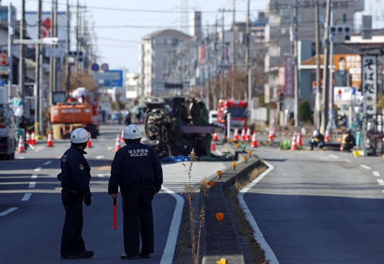 Excavadoras y personal de rescate trabajan para construir una pendiente para rescatar al chofer de un camión que se hundió en un socavón en Yashio, prefectura de Saitama.