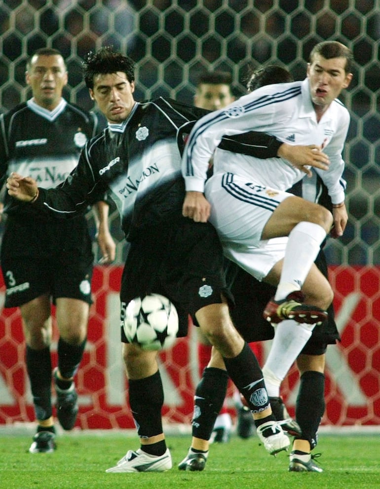 El "emperador" Julio César Cáceres, de Olimpia, disputa el balón con Zinedine Zidane, del Real Madrid, en la final de la Copa Intercontinental 2002.