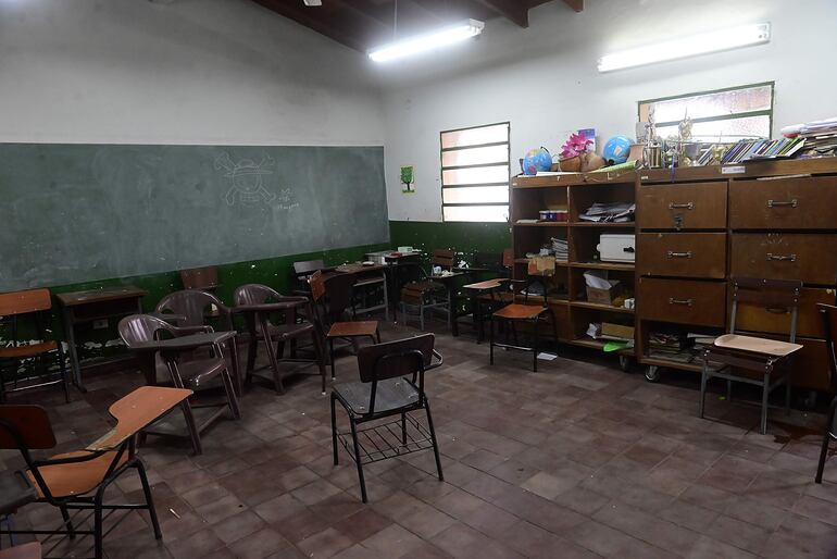 Aula con muebles viejos y pupitres en mal estado en una escuela pública de Asunción.